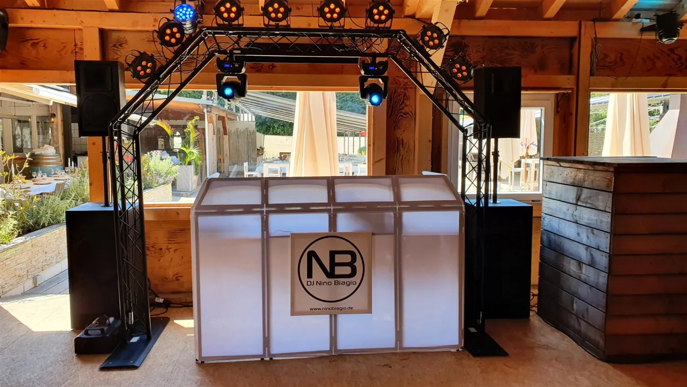 DJ-Setup im HubRaum Durlach: Traversenbogen, Movingheads und Lichtleisten in Blau zwischen Holzbalken